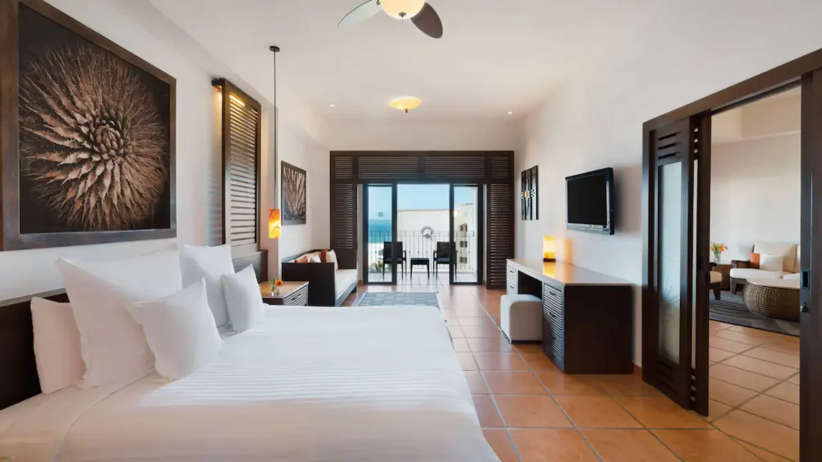 Club One Bedroom Master Suite bedroom with king bed, sitting area, and resort-view balcony at Hyatt Ziva Los Cabos.