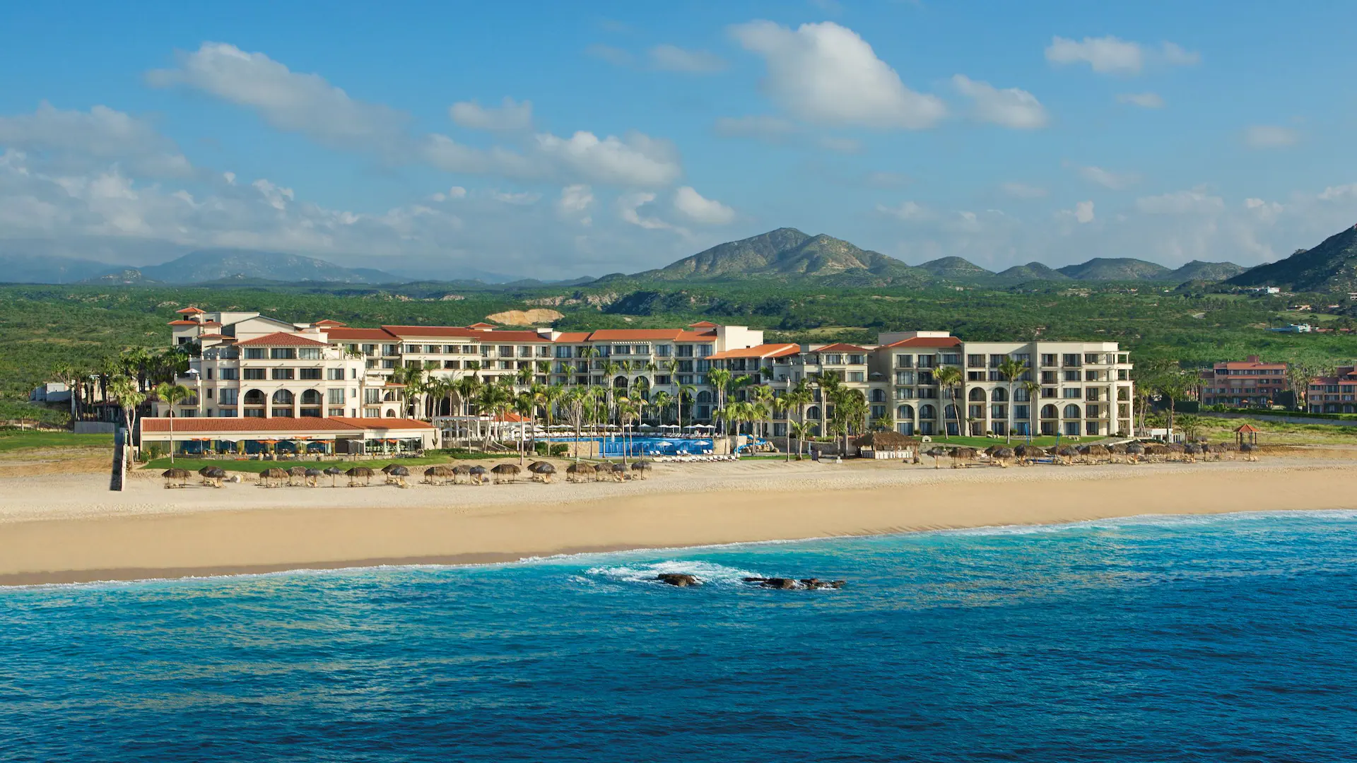Dreams Los Cabos Suites Golf Resort and Spa all-inclusive resort with beachfront pools, golf course access, and lush grounds in Los Cabos, Mexico.